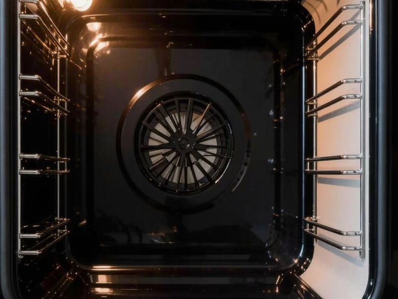 Inside of a spotless oven with clean racks and fan. Illustration.